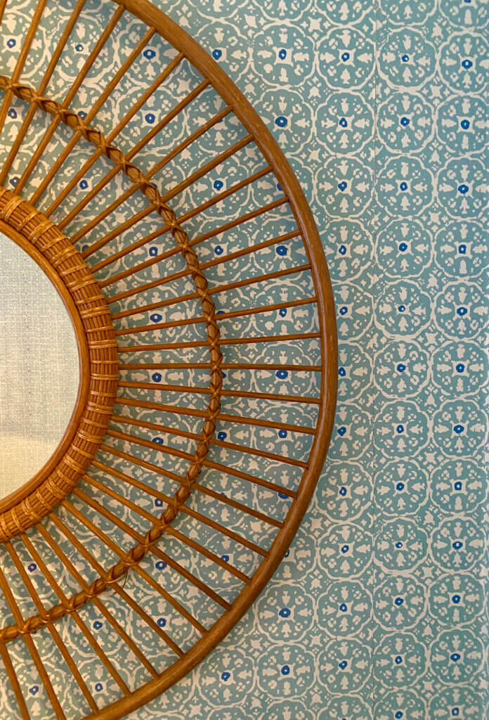 circular brown mirror on textured wallpaper